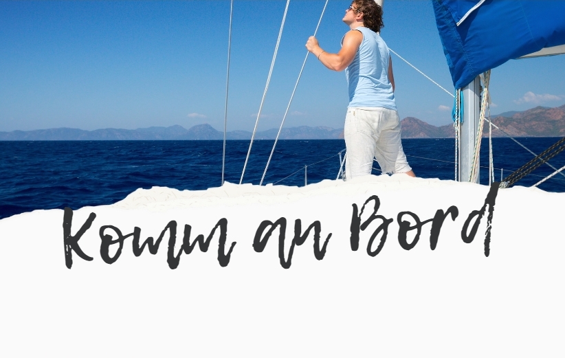 Ein Mann steht auf einem Boot an Deck und schaut relaxt in den Freiheits Himmel
